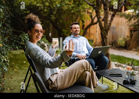Relaxing outdoor work meeting with colleagues collaborating in garden Stock Photo