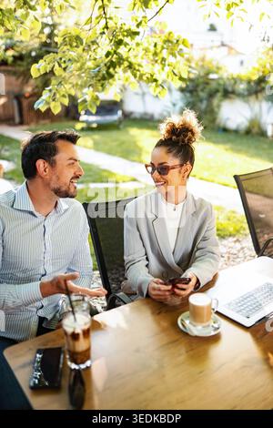 Business colleagues having outdoor coffee meeting discussing work Stock Photo