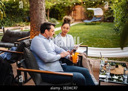Business people working on tablet outdoors, discussing project Stock Photo