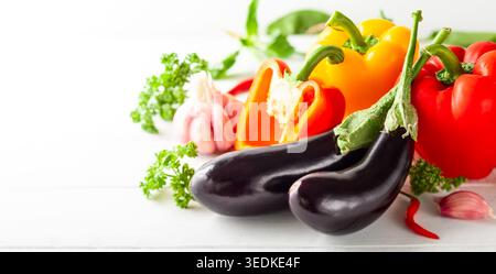 Various types of fresh vegetables and herbs on a  white wooden background. Concept of healthy eating, fresh vegetables. Stock Photo