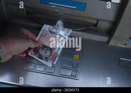 King Charles III Bank of England notes being dispensed from a UK ATM cash machine, showing the new monarch on British currency. Stock Photo
