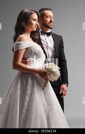 Studio shot of a newlywed couple on a grey background Stock Photo