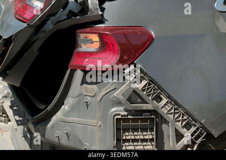 Damaged car rear reveals shattered elements after a sudden collision on road. Stock Photo