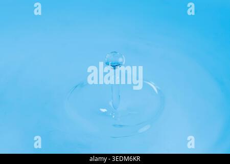A drop of water on a light blue background Stock Photo