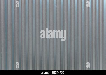 Close up of corrugated metal wall texture with vertical gray and silver stripes Stock Photo