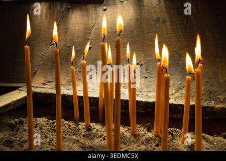 Candles in an Orthodox church. Burning votive candles placed in sand Stock Photo