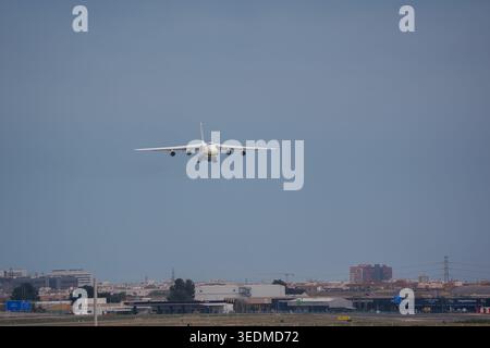 Heavy transport aircraft on final approach over airport urban perimeter Stock Photo