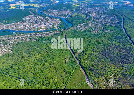 Aerial view of the expansive green canopy of the Forest of Fontainebleau and the meandering Seine river flowing past urban settlements Fontainebleau, Stock Photo