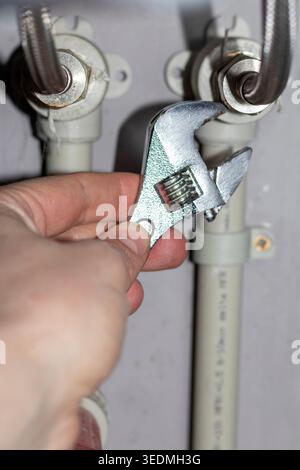 Plumber working on the plumbing drain pipes under a sink Stock Photo