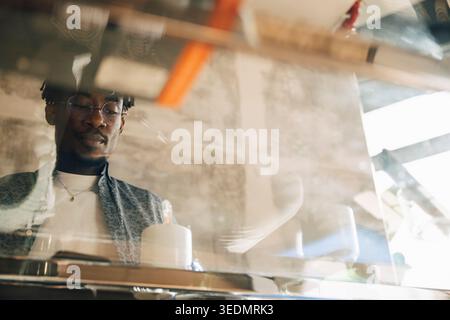 Low angle view of businessman seen through glass desk at office Stock Photo