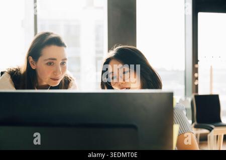 Businesswomen working together on desktop PC at creative workspace Stock Photo