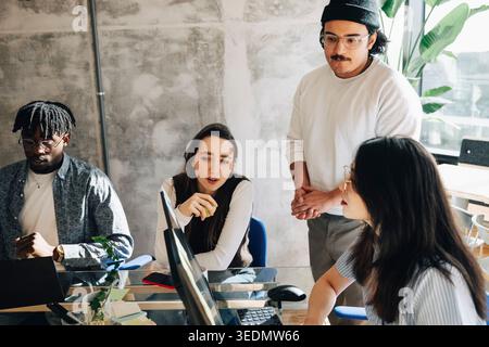 Group of entrepreneurs discussing strategies while working together at startup workspace Stock Photo