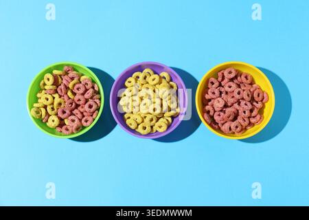 Different types of cereal in bowls on light blue background, flat lay Stock Photo