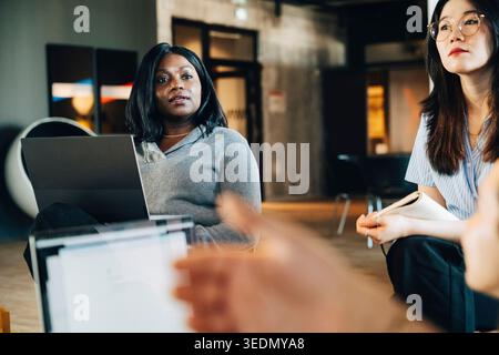 Businesswoman interacting with team during meeting at office Stock Photo