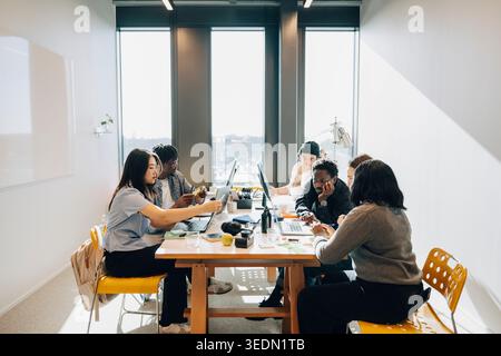 Group of diverse entrepreneurs working on project at their creative workspace Stock Photo