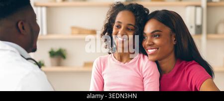 Conversation Between Doctor, Mother, and Daughter in a Healthcare Setting Stock Photo
