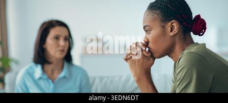 Two Women Having a Serious Conversation in an Indoor Setting During the Day Stock Photo