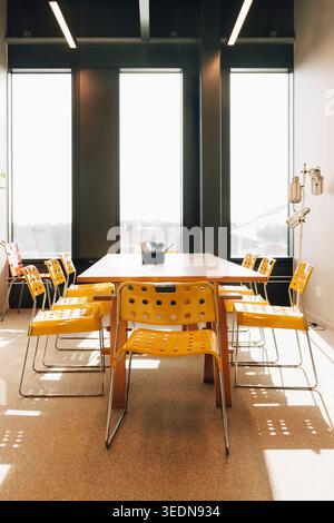 Modern conference room setup with yellow chairs and table Stock Photo