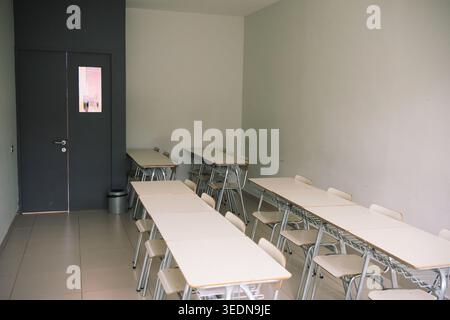 Empty modern classroom with rows of desks and chairs Stock Photo