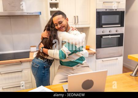 Loving multiethnic couple hugging in home kitchen Stock Photo
