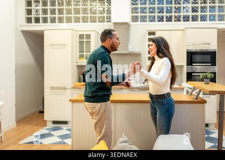 Happy couple dancing in a modern home kitchen Stock Photo