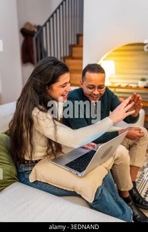 Happy couple enjoying video call using laptop at home Stock Photo