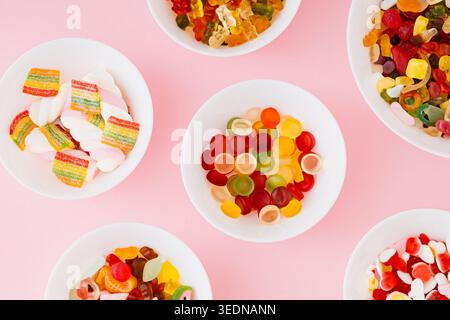 Creative pattern composition made of gummy candies on pastel pink background. Minimal trendy gummies concept. Jelly sweets aesthetic. Flat lay. Stock Photo