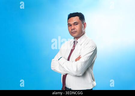 Portrait of a professional Indonesian executive in a white shirt and tie, looking at the camera with a confident and serious expression. Stock Photo