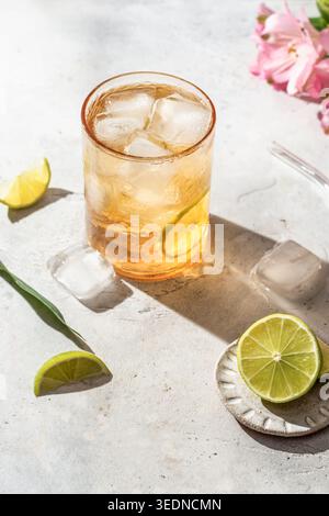 Cold tea in a glass with lime slice and ice cubes on white background. Refreshing iced summer drink Stock Photo