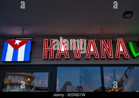 Neon Havana Sign With Cuban Flag Icon Above Restaurant Entrance At Dusk - the seaside town of Świnoujście. Stock Photo