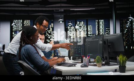 Technicians using PC in office, working with AI programming languages. Coworkers using computer in company workplace to do artificial intelligence tech quality assurance Stock Photo