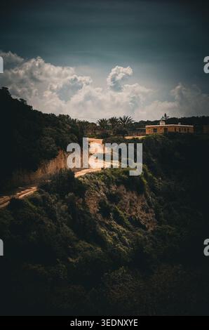 Rustic Pathway Through Lush Hillside with Building Stock Photo