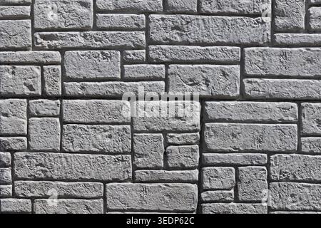 Gray stone wall texture showing a pattern of various sized rough blocks Stock Photo