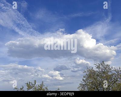 Large white cluster cloud Cumulus in the middle of the picture, above Schleierweolke, top left right Cirrocumulus, at the bottom in the background Str Stock Photo