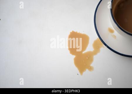 Coffee spills on a table near an empty cup Stock Photo