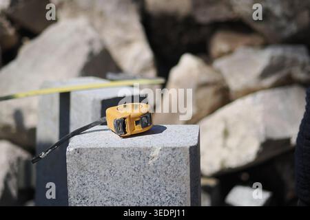Tape measure rests on stone during construction work Stock Photo