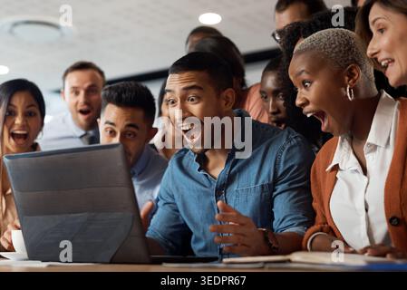 Excited, business people or winning with laptop in office for team promotion, success or achievement. Happy, group or shocked employees with surprise Stock Photo