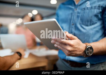 Hands, scrolling and tablet with business person in office for planning, research or review. App, digital and reading information with employee man in Stock Photo