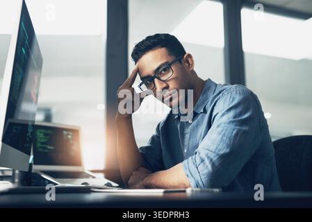 Man, portrait and programmer with computer in office for software engineering or cybersecurity. Male person, hacker or app developer with glasses or Stock Photo