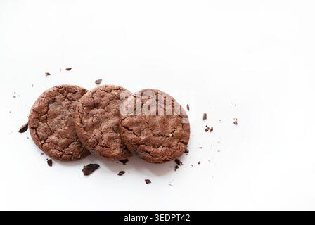 Dark chocolate chip cookies with crumbs isolated on white background. Food styling commercial stock photo. Stock Photo