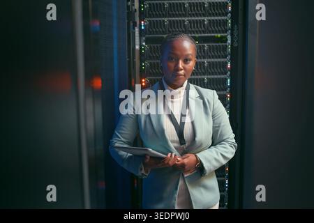IT, tablet and portrait of black woman in server room for database, diagnostics and inspection. Engineer, programming and person on tech with hardware Stock Photo