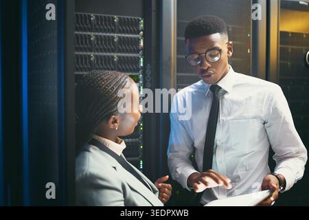 Maintenance, analysis or team in server room with tablet, network or system review in data center. Engineers, digital or black people with tech, fault Stock Photo