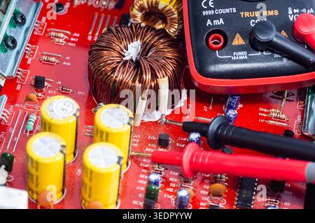 Multimeter with test probes and a circuit board Stock Photo