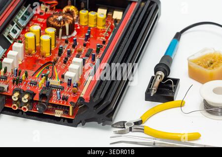 Multimeter with test probes and a circuit board lie on a white background. Stock Photo