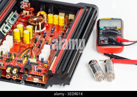 A multimeter with test probes and a circuit board and tube Stock Photo