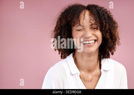 Woman, natural and excited in studio for haircare, growth and texture with mockup space. Person, curly hair and happy on pink background with laughing Stock Photo