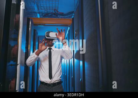 Inspection, technician and black man with vr headset in server room, repair simulation or metaverse. System check, tech or person with virtual Stock Photo