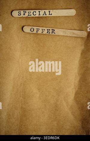 SPECIAL OFFER on wooden sticks over vintage brown paper texture. Vertical retro style image Stock Photo