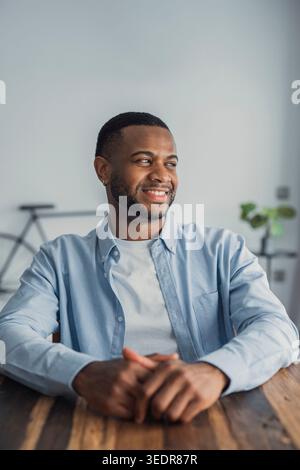 Visualizing success. Head shot of confident stylish young afro american cheerful man enjoying looking at window thinking happy thoughts. Smiling black hipster guy student businessman imagine good future Stock Photo