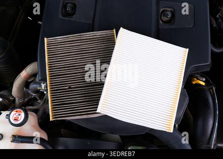 New vs. Dirty Engine Air Filter, A side-by-side comparison of a clean white car engine air filter and a dirty, clogged one Stock Photo